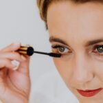 Elegant close-up shot of a woman applying mascara, highlighting beauty and makeup artistry.